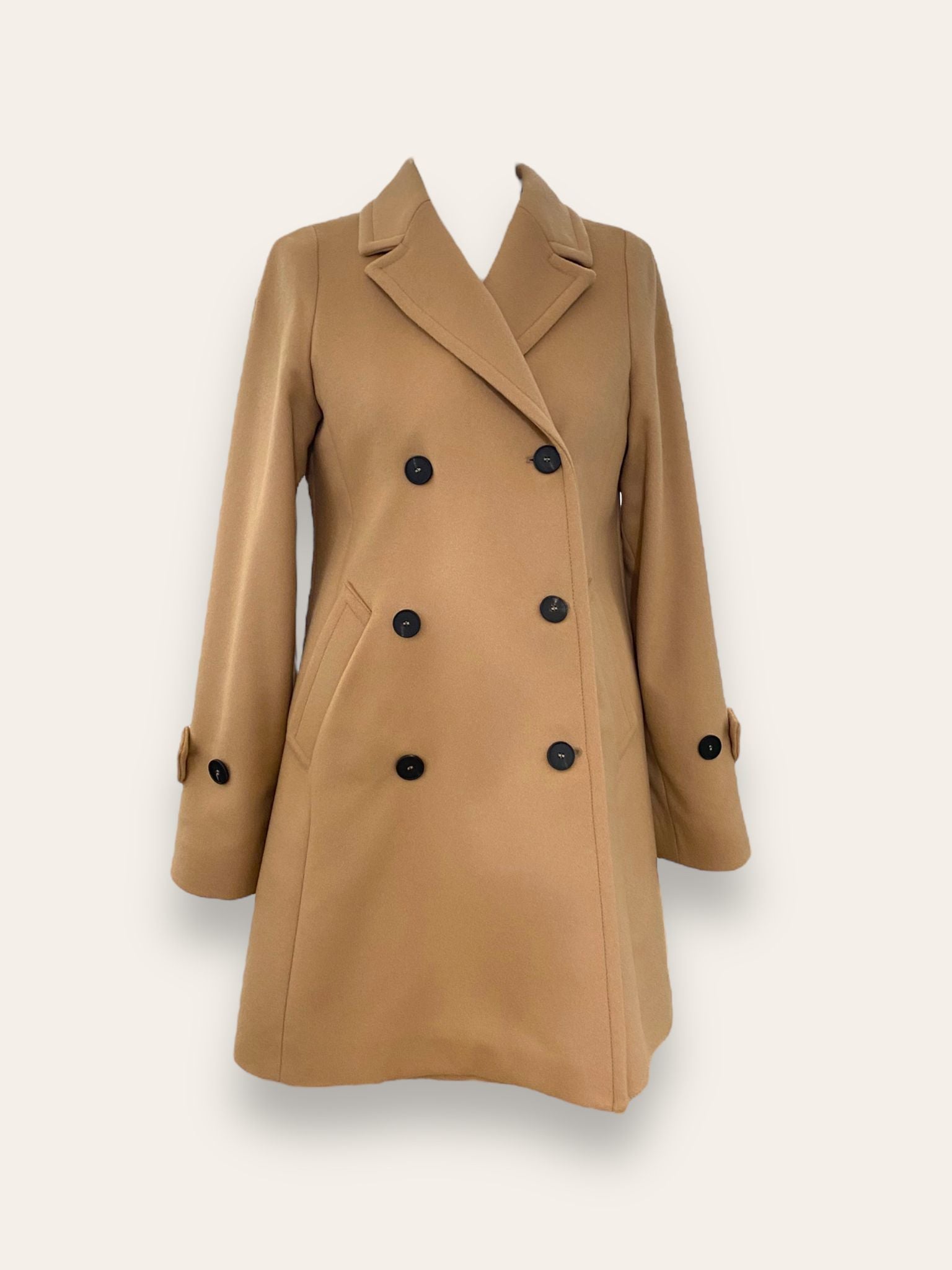 Scopri il cappotto trench Elvira color cammello di EVITA, realizzato con un pregiato mix di lana, poliammide e cashmere. Con il suo design classico e i bottoni neri, rappresenta l'artigianato italiano di alta qualità. Perfetto per un look sofisticato e senza tempo. Prodotto con passione da EVITA, made in Italy.