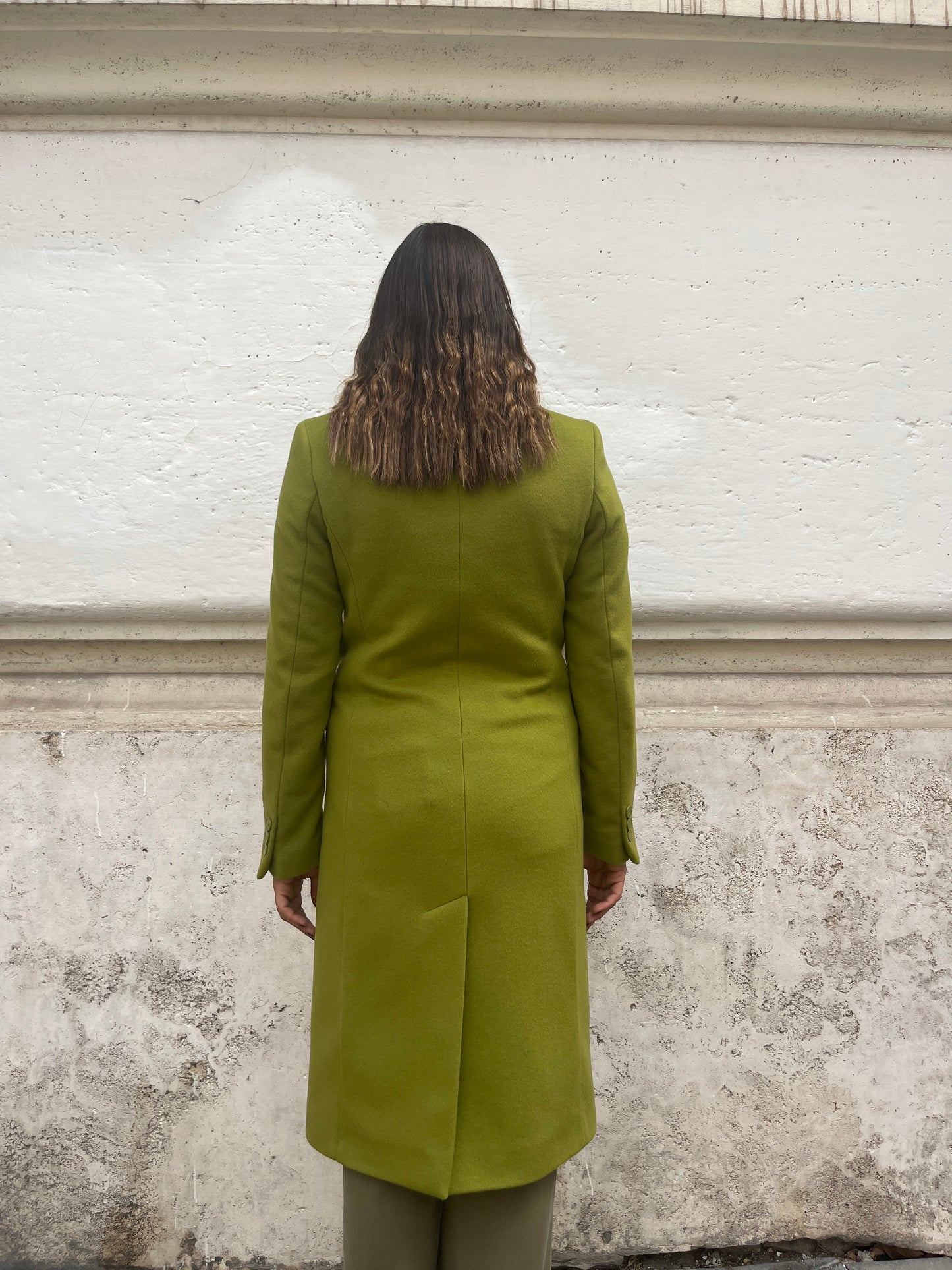  "Testo Alternativo: Cappotto Slim Fit Anastasia - Verde Pistacchio in Lana Cashmere e Viscosa. Bordature interne in raso rifinite a mano, abbottonatura semplice a tre bottoni, polso con bottoni e due tasche. Foderato per un comfort extra. Realizzato in sartoria con disponibilità per taglie, garantendo qualità e esclusività. La modella alta 1,70 m indossa la taglia 44, leggermente morbida per un look confortevole. Aggiungi un tocco regale al tuo stile con il Cappotto Anastasia di EVITA."