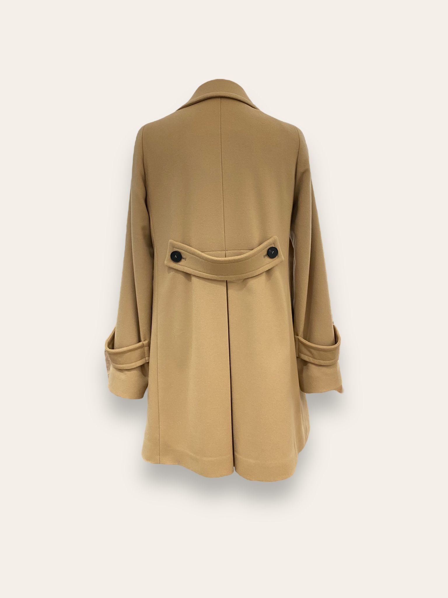 Scopri il cappotto trench Elvira color cammello di EVITA, realizzato con un pregiato mix di lana, poliammide e cashmere. Con il suo design classico e i bottoni neri, rappresenta l'artigianato italiano di alta qualità. Perfetto per un look sofisticato e senza tempo. Prodotto con passione da EVITA, made in Italy.